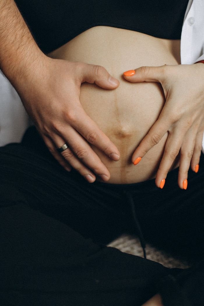 The Art of Drawing Readers In: Your attractive post title goes here A close-up shot of a couple lovingly touching a pregnant belly, symbolizing care and connection.